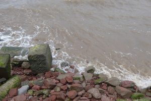 The sediment-laden Solway flows in past the viaduct embankment